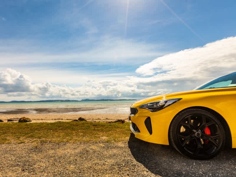 Yellow car parked at the beach.