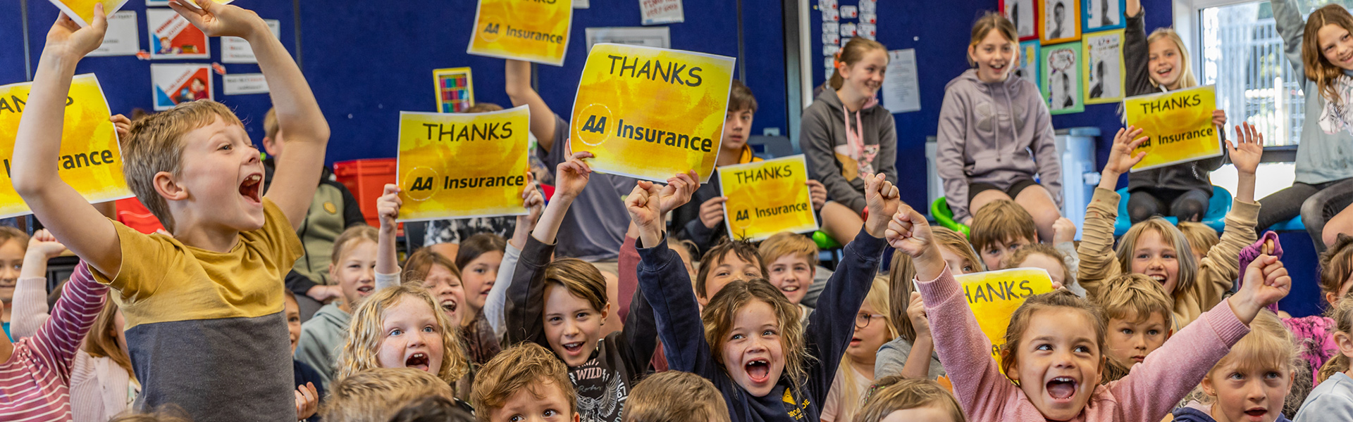 Cheering children holding up signs that say "Thanks AA Insurance"