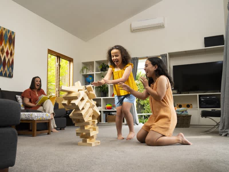 Children playing inside with wooden bricks.