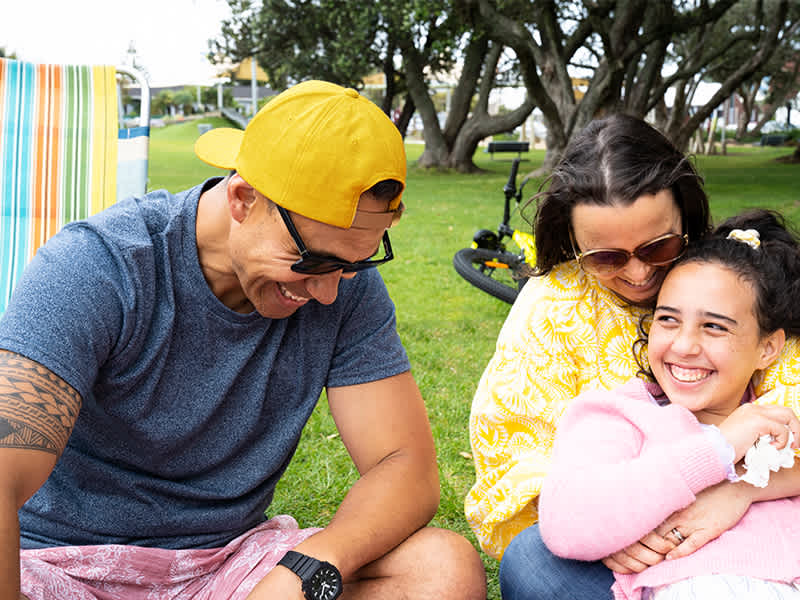 A family laughing in a park.