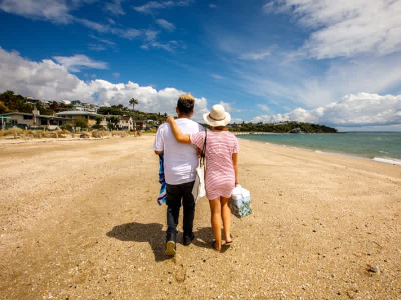 A couple walking down the beach in New Zealand