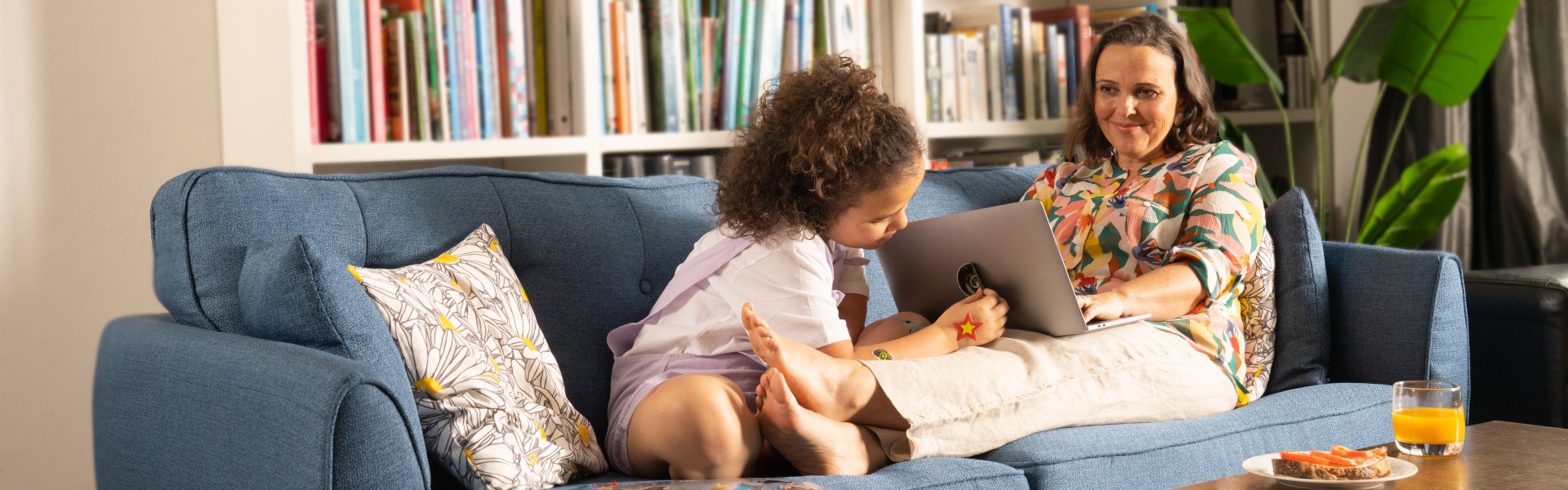 A mum and daughter relaxing on the couch.