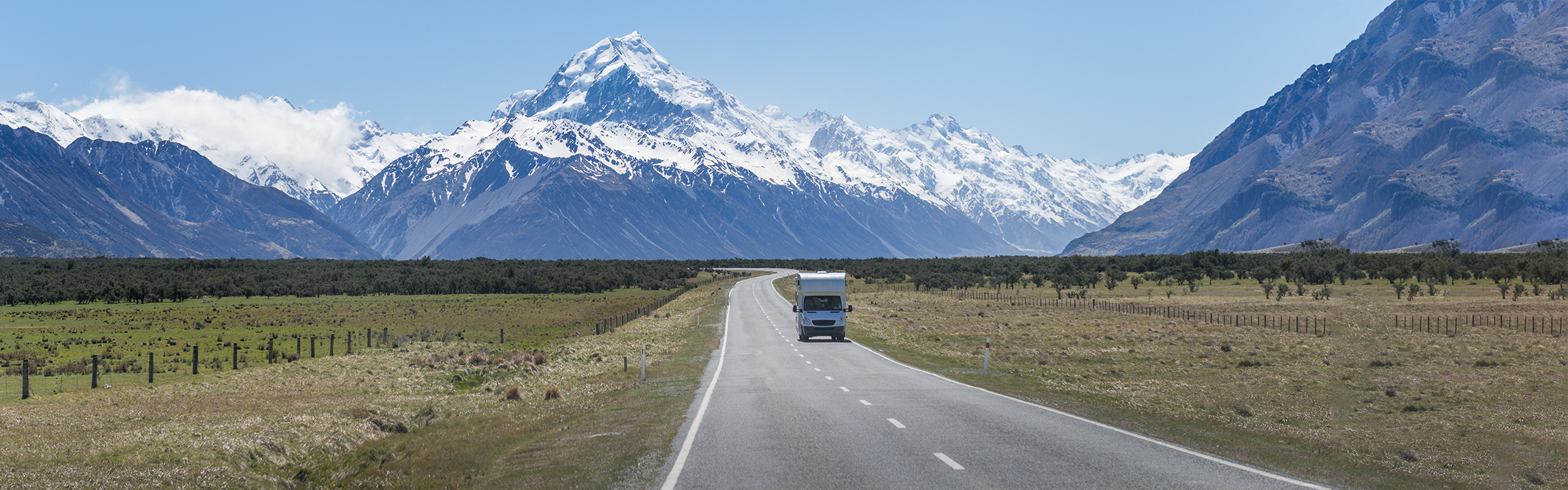 A van driving away from a mountain.