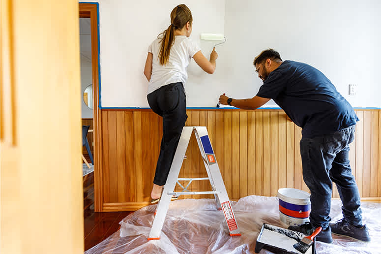 A couple painting a room in their home