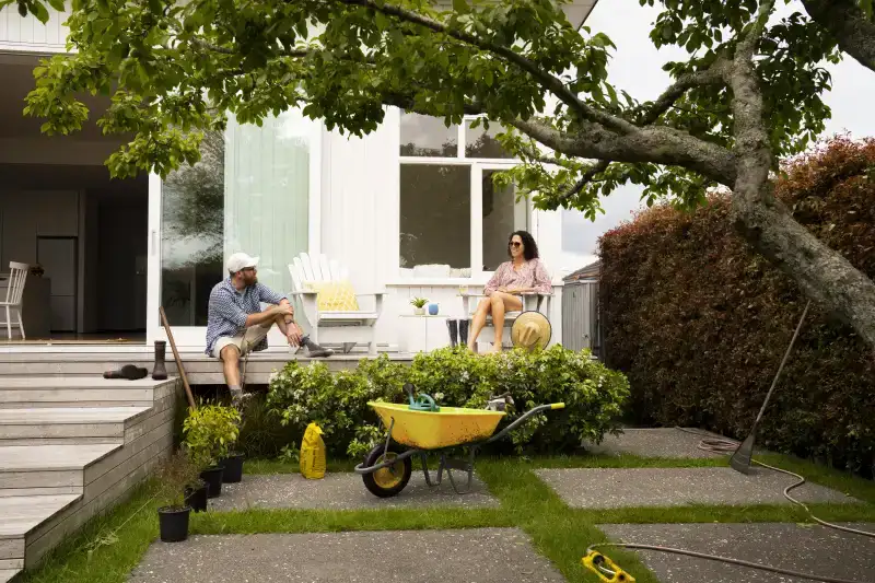 A couple taking a break from gardening their backyard.
