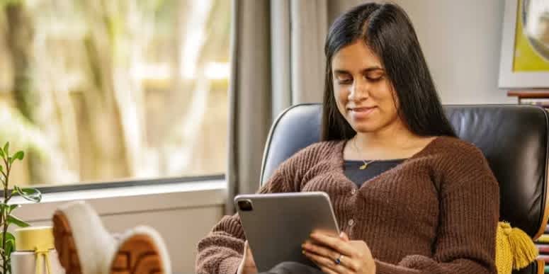 woman on couch looking at tablet