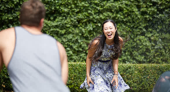 A woman in a dress is laughing and playing