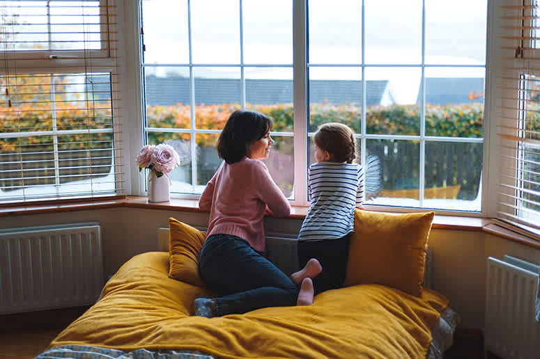 Two children enjoying the view from a bay window