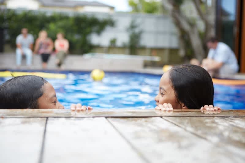 Two children playing in the pool on holiday